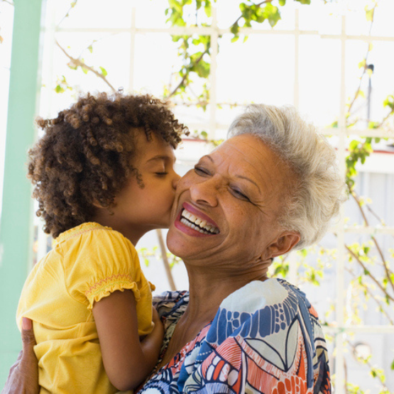 Grandchild kissing grandparent on cheek