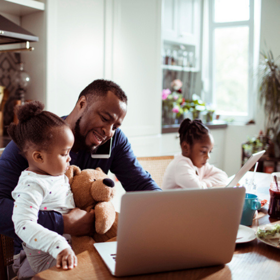 Family sitting at table and viewing laptop