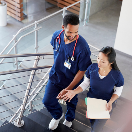 Male and female doctors walking up a staircase