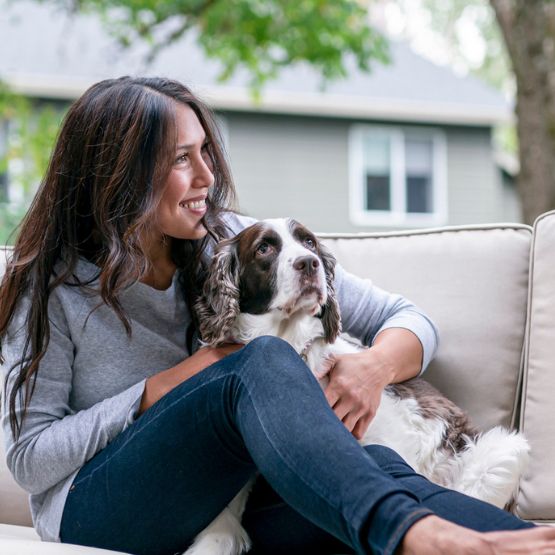 Woman and dog sitting on outdoor couch