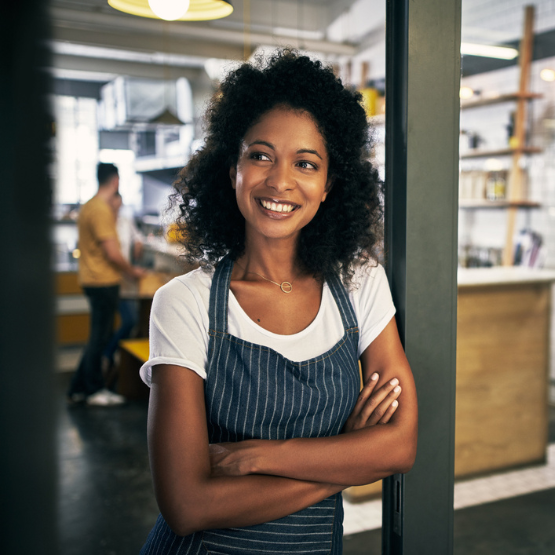 Smiling person leaning on doorway at work