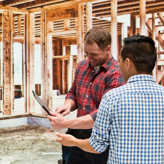 Builders looking at plans in house under construction