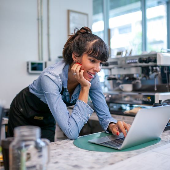 Woman at coffee shop working on laptop