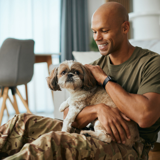 Smiling person petting dog