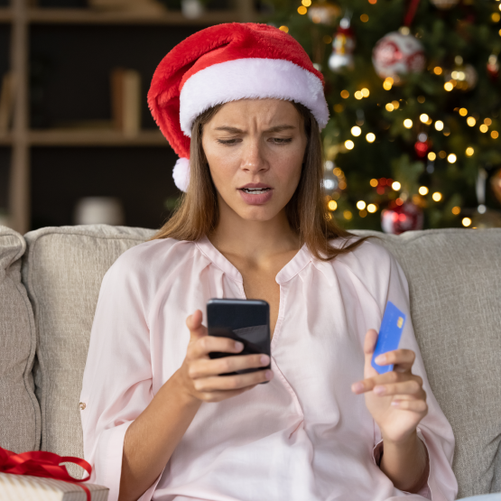 Woman wearing Santa hat using mobile phone