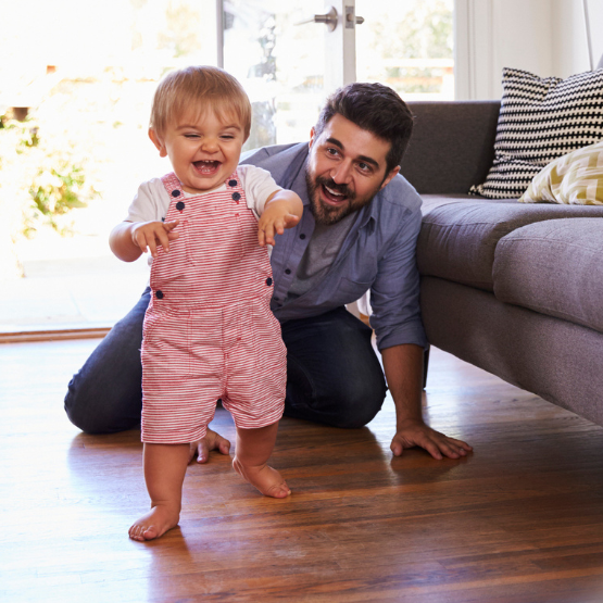 Dad watching young daughter's first steps