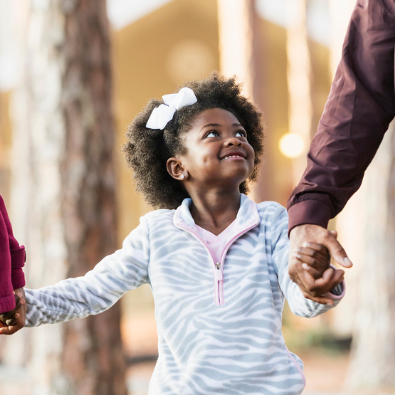 Young girl holding hands with adult