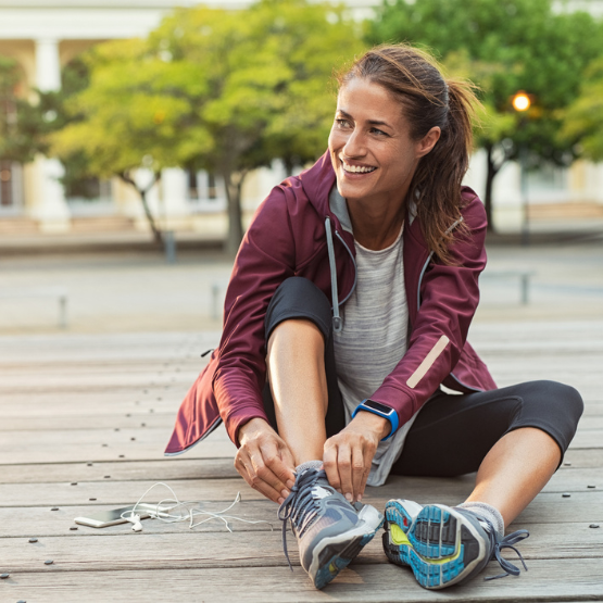 Female runner sitting and tying shoes