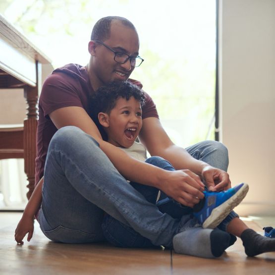 Father helping son tie his shoes