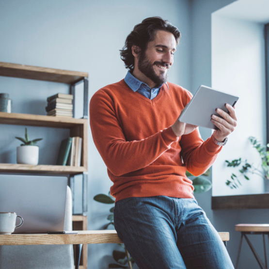 Person leaning on desk working on tablet